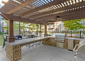 Thumbnail 19 of 37 - A patio with a table and chairs under a pergola at Glenwood at Grant Park, Atlanta, GA