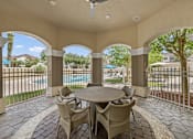 Thumbnail 23 of 38 - A patio with a table and chairs overlooking a pool.