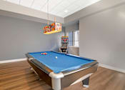 Thumbnail 12 of 26 - A pool table in a room with a light colored ceiling.
