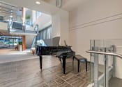 Thumbnail 24 of 26 - A black grand piano at the entryway to the building