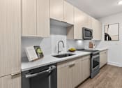 Thumbnail 2 of 42 - A modern kitchen with wooden cabinets and stainless steel appliances.