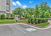 Thumbnail 34 of 42 - A parking lot with a green electric car charging station.