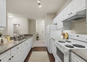 Thumbnail 2 of 38 - A modern kitchen with white cabinets and appliances.