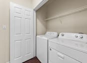 Thumbnail 9 of 38 - A white door is open to a laundry room with a washer and dryer.