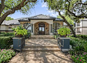 Thumbnail 28 of 38 - A house with a stone facade and a tiled roof is surrounded by greenery and has a pathway leading to the entrance.