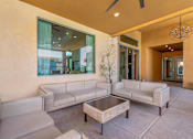 Thumbnail 21 of 29 - A modern living room with a glass wall and a ceiling fan.