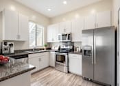 Thumbnail 6 of 29 - A modern kitchen with stainless steel appliances and white cabinets.