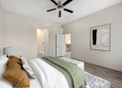 Thumbnail 3 of 29 - A bedroom with a bed, a ceiling fan, and a painting on the wall.