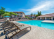 Thumbnail 1 of 37 - Resort-Style swimming pool surrounded by lounge chairs and umbrellas
