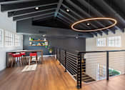 Thumbnail 25 of 37 - A modern dining area with a black railing and a wooden floor.
