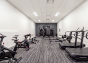 Thumbnail 21 of 37 - A gym with treadmills and exercise bikes.