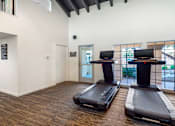 Thumbnail 20 of 37 - Two treadmills are placed in a spacious room with a white wall and a window.