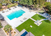 Thumbnail 10 of 36 - An aerial view of a swimming pool surrounded by a grassy area and trees.