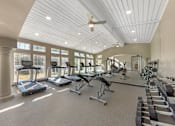 Thumbnail 23 of 36 - A gym with treadmills, elliptical machines, and other exercise equipment.
