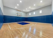 Thumbnail 16 of 36 - A basketball court with a blue mat and a basketball hoop.