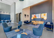 Thumbnail 24 of 27 - A modern living room with blue chairs and a grey couch.