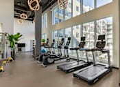 Thumbnail 23 of 27 - A gym with treadmills and exercise equipment.
