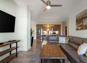 Thumbnail 3 of 27 - A modern living room with a brown leather couch and a wooden coffee table.