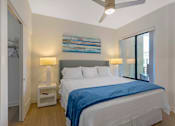 Thumbnail 4 of 27 - A bedroom with a bed, two lamps, and a ceiling fan.