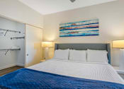 Thumbnail 5 of 27 - A bedroom with a large bed and a painting on the wall.