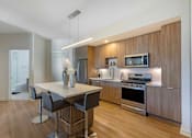 Thumbnail 2 of 27 - A modern kitchen with a dining table and chairs.