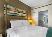 Thumbnail 8 of 27 - A bedroom with a large bed and a painting on the wall.