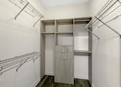 Thumbnail 13 of 27 - A walk-in closet with shelving and hanging space.