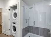 Thumbnail 10 of 27 - A white laundry room with a washer and dryer in a cabinet.