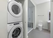 Thumbnail 12 of 27 - A white Whirlpool washing machine in a laundry room.