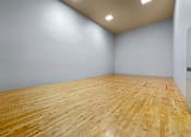 Thumbnail 20 of 28 - Indoor racquetball court with wooden floors and high ceilings