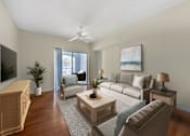 Thumbnail 2 of 28 - A living room with a couch, a chair, a coffee table, and a painting on the wall.