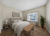 Thumbnail 5 of 28 - A bedroom with a bed, nightstand, and window.