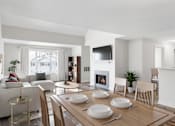 Thumbnail 1 of 26 - A modern dining room with a fireplace and a TV mounted on the wall at Residences at Westborough Station, Westborough, MA