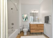 Thumbnail 5 of 34 - a bathroom with a toilet sink and shower and a mirror at The Merc, Waltham, MA