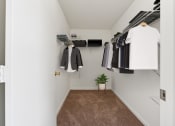 Thumbnail 38 of 40 - a walk in closet with clothes hanging on the wall and a door to the closet at Residences at Westborough Station, Massachusetts, 01581