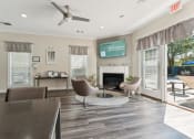 Thumbnail 37 of 40 - a living room with a fireplace and a table and chairs at Residences at Westborough Station, Westborough, MA