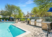 Thumbnail 22 of 40 - a swimming pool with a grill next to a resort style pool at Residences at Westborough Station, Massachusetts, 01581
