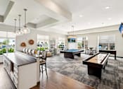Thumbnail 17 of 29 - A spacious living room with a pool table and a kitchen area.
