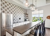Thumbnail 18 of 29 - A kitchen with a stainless steel refrigerator and a patterned backsplash.