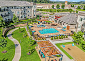 Thumbnail 27 of 29 - A large outdoor pool area with a wooden deck and a hot tub.