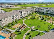 Thumbnail 28 of 29 - A large apartment complex with a swimming pool and a landscaped area.