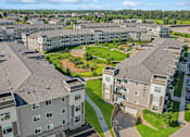 Thumbnail 29 of 29 - A large apartment complex with multiple buildings and a green lawn in the foreground.