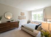 Thumbnail 5 of 33 - a bedroom with a bed, dresser,  and a window at Edgebrook Residences, New Hampshire
