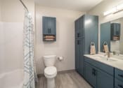 Thumbnail 10 of 33 - a bathroom with blue cabinets at Edgebrook Residences, Merrimack New Hampshire