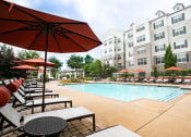 Thumbnail 29 of 40 - Pool with loungers and umbrellas at Emblem Alpharetta, Alpharetta, GA