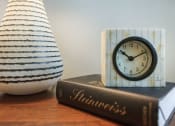 Thumbnail 16 of 50 - bedside table with book, clock and vase at The Canyons at Linda Vista Trail, Oro Valley, Arizona