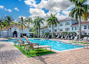 Thumbnail 18 of 41 - A pool surrounded by palm trees and lounge chairs.