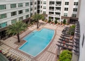 Thumbnail 7 of 31 - an overhead view of a swimming pool in front of an apartment building at The Rialto, Orlando, FL