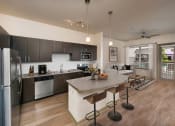 Thumbnail 31 of 31 - a kitchen and living room with dark wood cabinets and a granite countertop