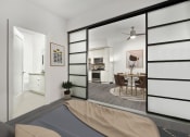 Thumbnail 3 of 12 - a bedroom with a bed and sliding doors that open to the kitchen and dining area  at SLX Atlanta, Georgia, 30341
